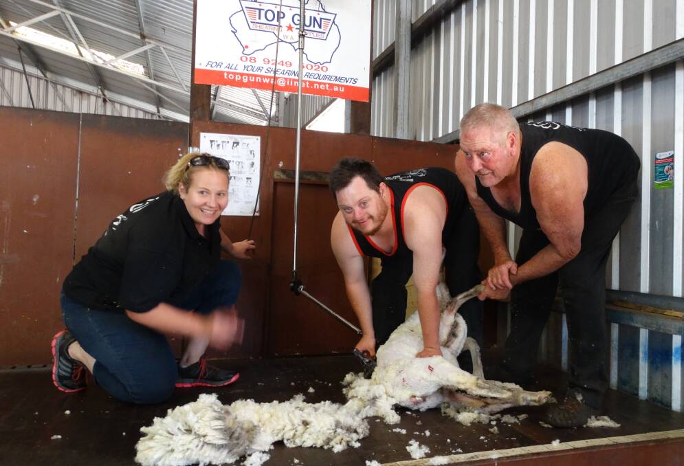 Busy Ben: Ben Keenan (centre) enjoying shearing with wool handler Amanda Davis and shearing trainer Kevin Gellatly. Photo: Supplied