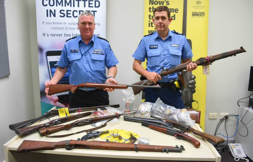 Inspector Peter Morrissey and acting senior sergeant Paul Williams hold up two of the 59 guns handed in to police across the South West region during the national gun amnesty. Photo: Andrew Elstermann. 