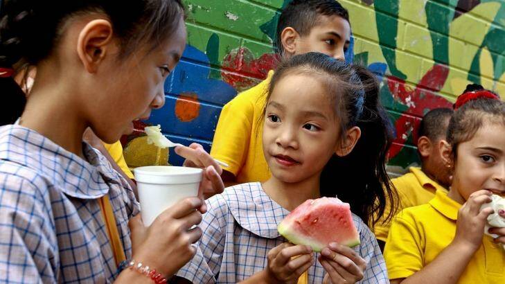 Cabramatta Public School children eat rice pudding and watermelon supplied by Foodbank. Photo: Ben Rushton