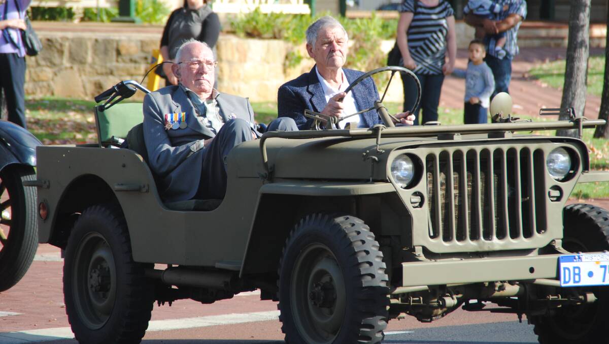 Arthur Scanlan and Verne Smithers lead off the parade in a model 42 World War 2 jeep. 