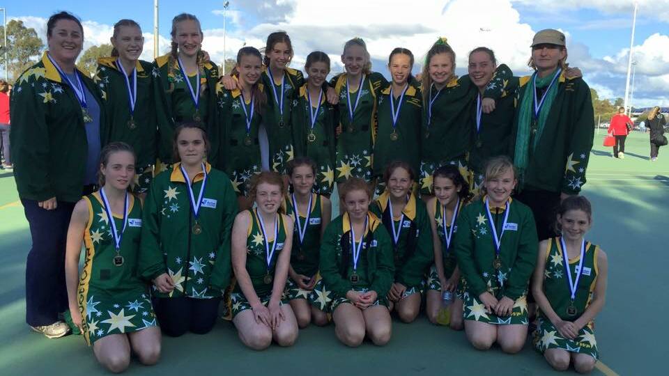 Coaches Julie Pike and Megan Burvill stand proudly with the Under 14's and Under 12's netball teams that won their respective competition in Bunbury last weekend. 