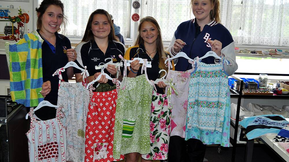 Heidi Rodgers, Bianca Masters, Claire Nitske and Nikki Van Bavel with dresses they have made for young girls living in poverty. 