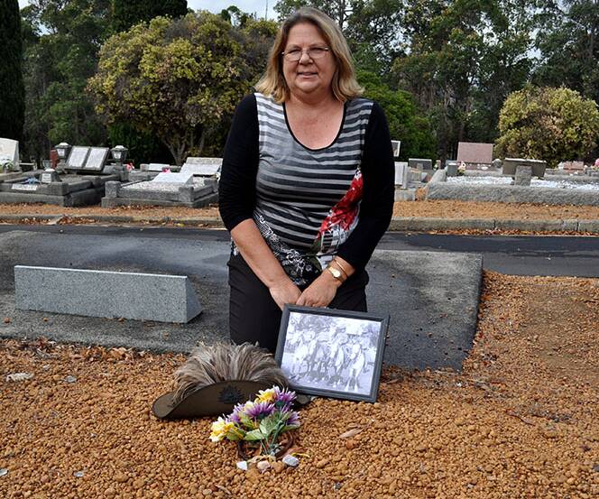 Desne Chapman sits at the head of the unmarked grave of her great grand-uncle in Bridgetown. 