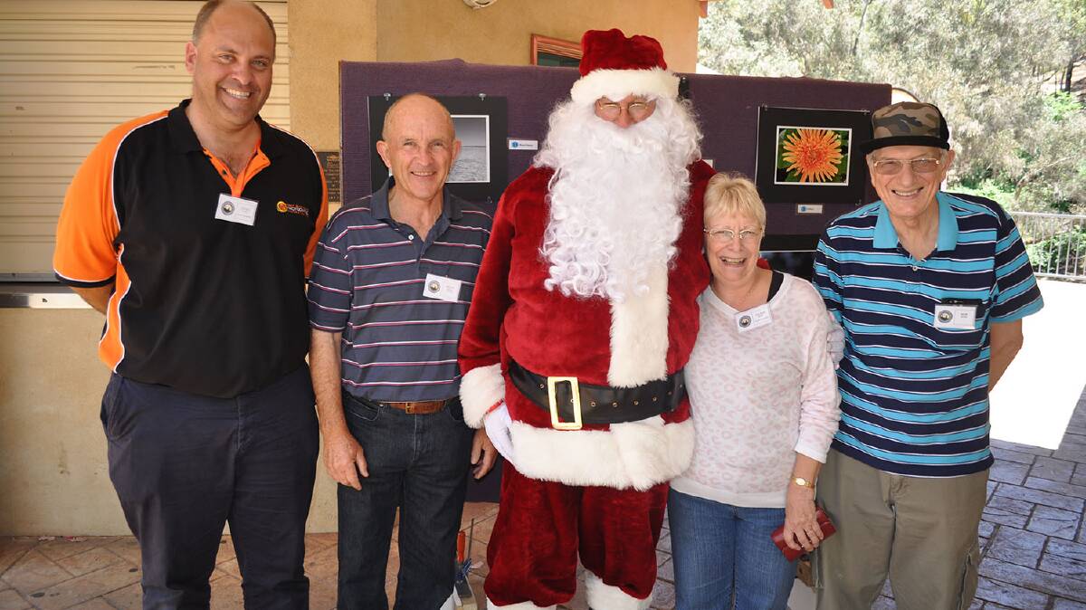 Santa Claus poses with Craig White, Brian Deans, Jackie and Bob Howe. 
