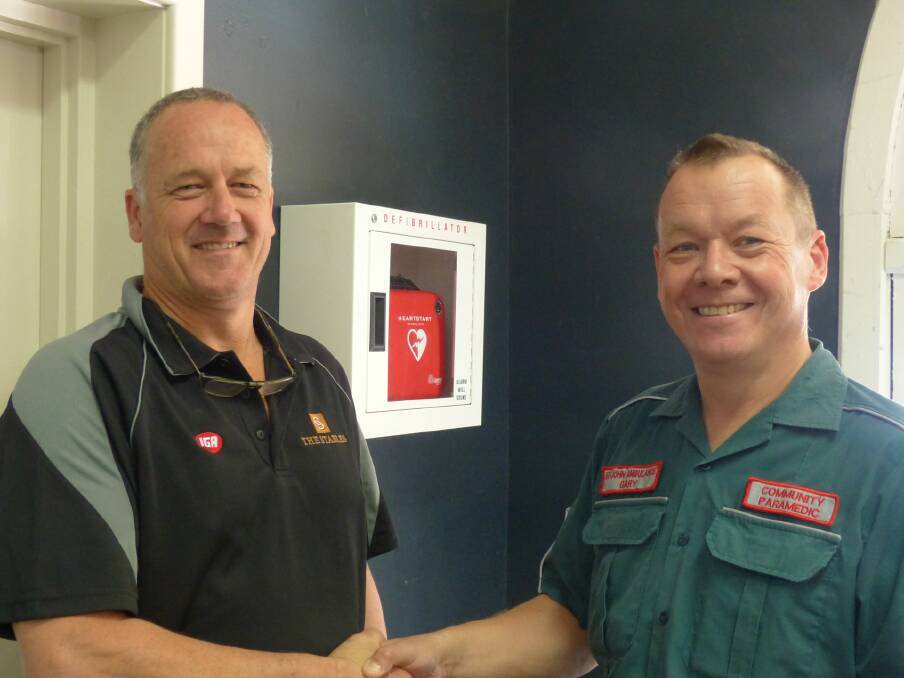 Thanks: Warren District community paramedic Gary Wilcox present a defibrillator Maurice Owen at The Stables IGA.