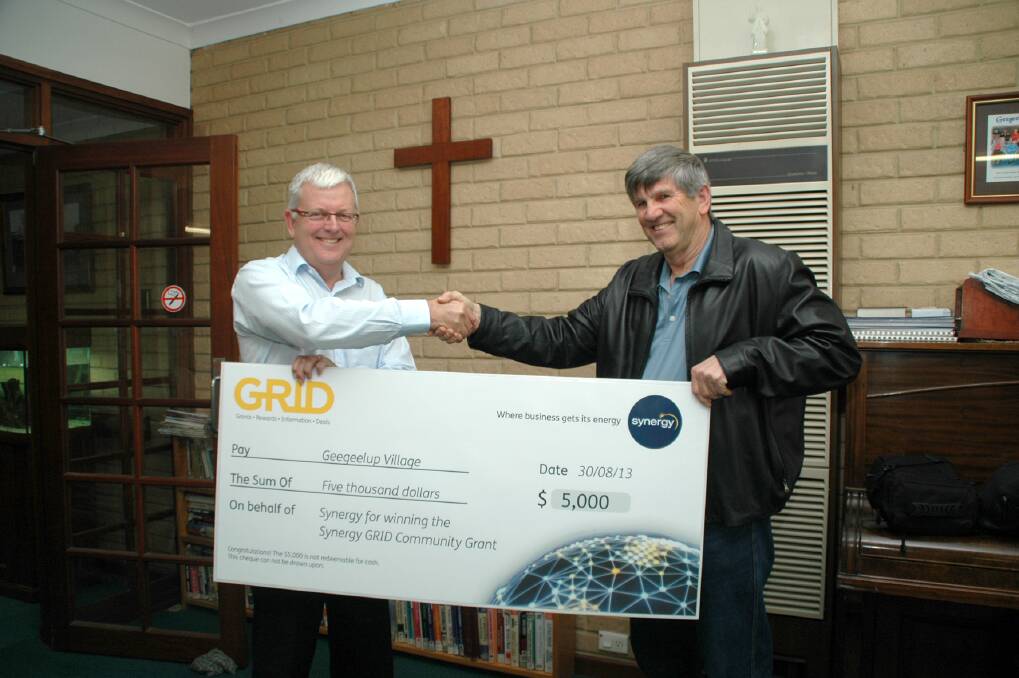 Funds: Synergy general manager of energy markets Geoff Roberts hands over a cheque for $5000 to Geegeelup Village treasurer and administrator Steve Webb.