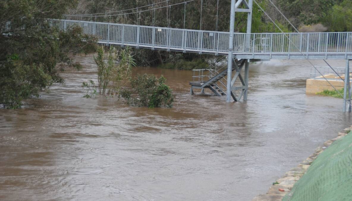 Preston River rises around the footbridge.