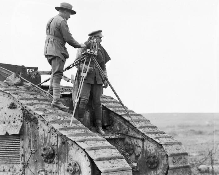 VANTAGE POINT: Captain George Wilkins (right) uses a disabled Mark V tank to gain elevation near the Hindenburg Line late in 1918. Picture: AWM E03915