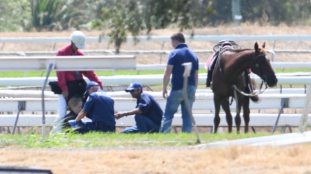 INCIDENT: Paramedics rushed to the scene to treat the jockeys that had been dislodged from their horses. Photo: Gareth Gardner