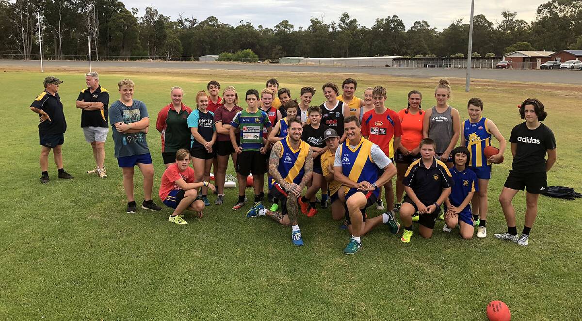 TRAINING: Year 8/9 club members pose for a photo with Dane Swan and Glen Jakovich, after soaking up some knowledge on the training track. Photo: Lee Steinbacher.