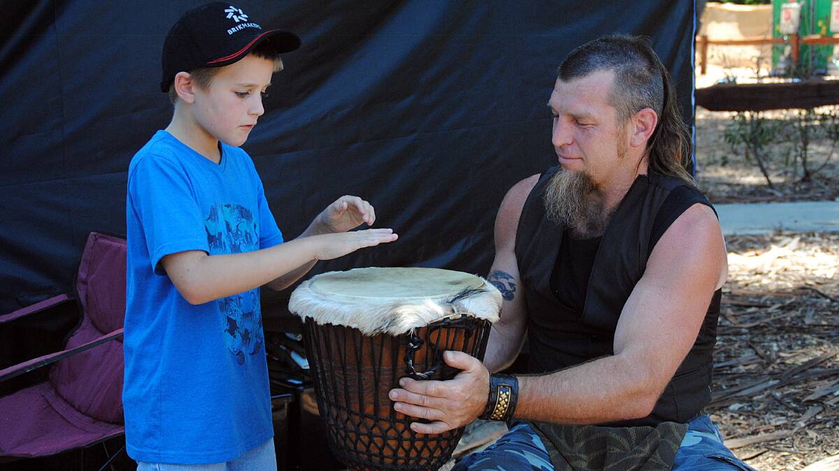 Corley McLernon from Bridgetown gets an on the spot drumming lesson from Ben Cody.
